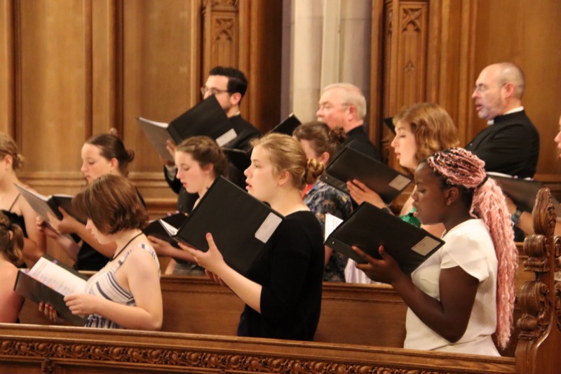 Choristers and adults rehearsing in the choir stalls at Duke Chapel