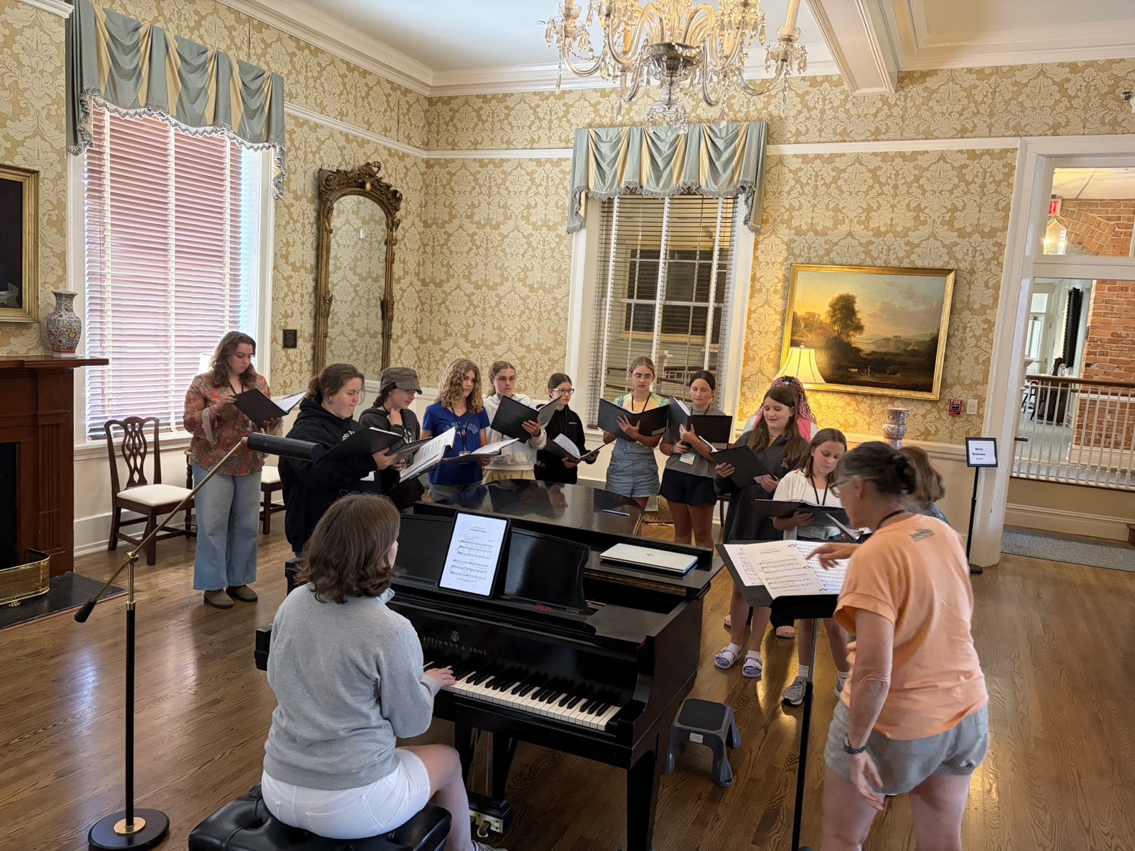 Choristers rehearsing around a piano